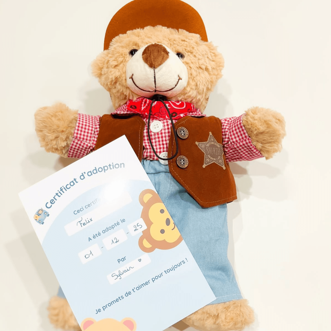 Ours en tenue de cow-boy tenant son certificat d’adoption rempli à la main